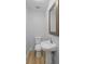 Powder room featuring a pedestal sink, decorative mirror and wood-look flooring at 2128 Kimberly Rd, Atlanta, GA 30331