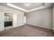 Bright bedroom with a tray ceiling, plush carpet, and a view into the ensuite bathroom at 2629 Irwell Way, Lawrenceville, GA 30044