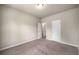 A carpeted bedroom with neutral walls and white trim, featuring two white doors at 2629 Irwell Way, Lawrenceville, GA 30044