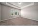 Cozy bedroom featuring plush carpeting and a tray ceiling with a ceiling fan at 2629 Irwell Way, Lawrenceville, GA 30044