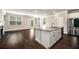 Open concept kitchen with stainless steel appliances and an eat-in island, flowing into a living area at 2629 Irwell Way, Lawrenceville, GA 30044