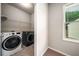 Convenient laundry room with modern washer and dryer, plus built-in shelving at 2629 Irwell Way, Lawrenceville, GA 30044