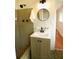 Bathroom featuring a shower, green tiles, stylish vanity with a sleek faucet and round mirror, creating a chic space at 5254 Corinth Dr, Stone Mountain, GA 30087