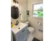 Bathroom includes vanity with dark hardware, a round mirror and natural light at 5254 Corinth Dr, Stone Mountain, GA 30087