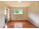Bedroom featuring hardwood floors, neutral paint, and view of backyard through the window at 5254 Corinth Dr, Stone Mountain, GA 30087