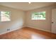Bedroom with hardwood floors, two windows and neutral walls with white trim at 5254 Corinth Dr, Stone Mountain, GA 30087