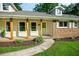 Welcoming front porch with natural wood columns and a vibrant green door at 5254 Corinth Dr, Stone Mountain, GA 30087