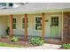 Beautiful porch with wooden columns, a green door, and manicured landscaping at 5254 Corinth Dr, Stone Mountain, GA 30087
