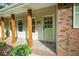 Inviting front porch with wooden pillars and a charming green front door at 5254 Corinth Dr, Stone Mountain, GA 30087