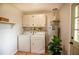 Laundry room with modern washer and dryer, overhead cabinets, and wood floors at 5254 Corinth Dr, Stone Mountain, GA 30087