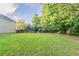Expansive backyard featuring green grass and mature trees at 6528 Carriage Ln, Stone Mountain, GA 30087