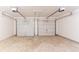 Two-car garage with dual overhead doors and concrete floor at 6528 Carriage Ln, Stone Mountain, GA 30087