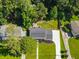 Aerial view of a well-maintained property showcasing solar panels, a driveway, mature trees, and lush landscaping at 1373 Brawley Ne Cir, Brookhaven, GA 30319
