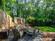 Serene backyard seating area with a fire pit, surrounded by lush greenery and a shed, creating a relaxing retreat at 1373 Brawley Ne Cir, Brookhaven, GA 30319