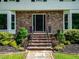 Inviting front entrance featuring brick steps, manicured landscaping, and a classic black door at 1373 Brawley Ne Cir, Brookhaven, GA 30319