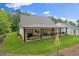Spacious backyard with covered patio, stone fireplace, ceiling fans, and outdoor kitchen at 2490 S Carroll S St, Villa Rica, GA 30180