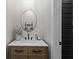 Bathroom featuring a wood vanity, a round mirror, and black paneled door at 2490 S Carroll S St, Villa Rica, GA 30180
