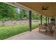 The covered patio has a ceiling fan, stone fireplace, and outdoor dining area overlooking the yard at 2490 S Carroll S St, Villa Rica, GA 30180