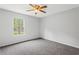 Bedroom features neutral carpet, ceiling fan, and a large window at 3833 Paddington Trail, Rex, GA 30273