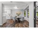 Bright dining area features modern lighting, wood floors, and a glass table near the updated kitchen at 3833 Paddington Trail, Rex, GA 30273