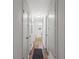 Long hallway featuring wood floors, white trim, and access to multiple rooms at 3833 Paddington Trail, Rex, GA 30273