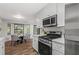 Well-lit kitchen boasts modern appliances, quartz countertops, and a view of the sunroom at 3833 Paddington Trail, Rex, GA 30273