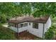 A rear exterior shows an enclosed porch, basement access, and mature trees at 3833 Paddington Trail, Rex, GA 30273