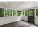 Bright sunroom featuring wood floors, and large windows offering scenic backyard views at 3833 Paddington Trail, Rex, GA 30273