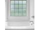 Close-up of a bathtub with a tiled window providing natural light at 7027 Walham Grv, Duluth, GA 30097