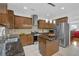 Spacious kitchen with stainless appliances, wood cabinetry, kitchen island, and tile backsplash, offering modern convenience at 7027 Walham Grv, Duluth, GA 30097