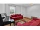 Cozy living room with bright light features red sofas and a piano, creating a comfortable and inviting atmosphere at 7027 Walham Grv, Duluth, GA 30097