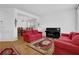 Bright living room features red sofas, a piano, and decorative rugs over hardwood flooring, creating an inviting space at 7027 Walham Grv, Duluth, GA 30097