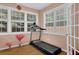 Bright sunroom with hardwood floors, large windows, and a treadmill for a home gym at 7027 Walham Grv, Duluth, GA 30097