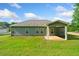 Home exterior with a covered back patio and a lush green yard under a partly cloudy sky at 110 Collingwood Lndg, Covington, GA 30016