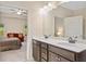 Bathroom featuring double sink vanity with white countertop, dark wood cabinetry, and access to the main bedroom at 110 Collingwood Lndg, Covington, GA 30016