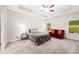 Large bedroom featuring a tray ceiling, plush carpet, and two windows with backyard views at 110 Collingwood Lndg, Covington, GA 30016