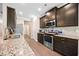 Stylish kitchen featuring granite countertops, stainless steel appliances, and dark cabinetry at 110 Collingwood Lndg, Covington, GA 30016
