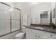 Modern bathroom with white cabinets, stone countertop, and a shower with glass doors at 205 Maplewood Dr, Roswell, GA 30075
