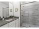 Bright bathroom featuring a walk-in shower with tile surround, single vanity with white countertop at 205 Maplewood Dr, Roswell, GA 30075
