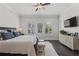 Bedroom with hardwood floors, a ceiling fan, mounted TV and windows with plantation shutters at 205 Maplewood Dr, Roswell, GA 30075