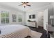 Bedroom boasts dark wood floors, a ceiling fan, mounted TV and lots of bright, natural light at 205 Maplewood Dr, Roswell, GA 30075
