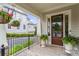 Covered porch showcasing brick flooring, iron railings, and decorative hanging plants at 205 Maplewood Dr, Roswell, GA 30075