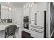 White kitchen featuring stainless steel appliances, modern lighting, and neutral backsplash at 205 Maplewood Dr, Roswell, GA 30075