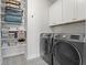 Laundry room with patterned tile, modern washer and dryer, and ample storage at 205 Maplewood Dr, Roswell, GA 30075
