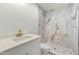 Bright bathroom with marble tile shower, stone floor, modern vanity, and brushed gold hardware at 381 Warner Se St, Marietta, GA 30060