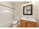 Bathroom includes vanity with framed mirror, light fixture, and tub with tile surround at 381 Warner Se St, Marietta, GA 30060