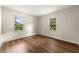 Bedroom featuring pristine white trim, two windows, and rich wood-style flooring at 381 Warner Se St, Marietta, GA 30060