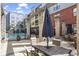 Community outdoor patio seating area with umbrellas and pool in the background at 401 16Th Nw St # 1357, Atlanta, GA 30363