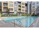 Sparkling community pool with lounge chairs, palm trees, and nearby building at 401 16Th Nw St # 1357, Atlanta, GA 30363