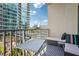 Balcony view with seating, table, and pillows, set against a backdrop of urban cityscape under a blue sky at 943 Peachtree Ne St # 902, Atlanta, GA 30309